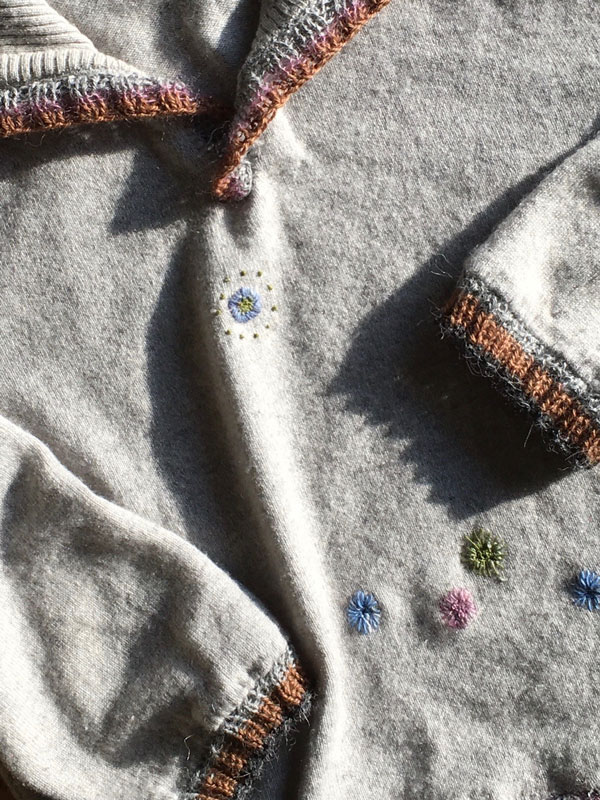 Upcycling-Beispiel: Löcher im Pullover mit Visual-Mending verschönert.